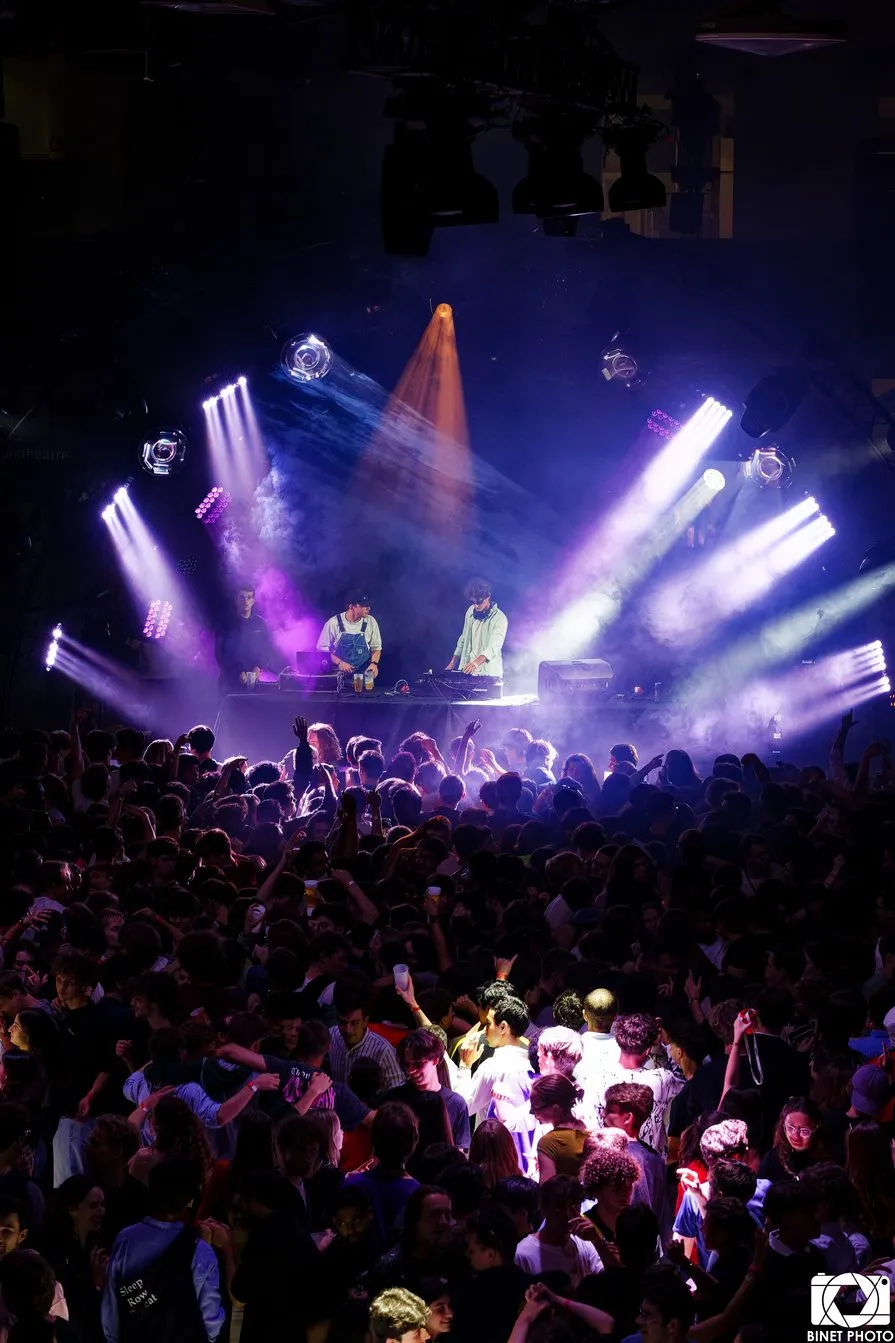 DJ set et jeux de lumière violets au-dessus d’une foule en fusion